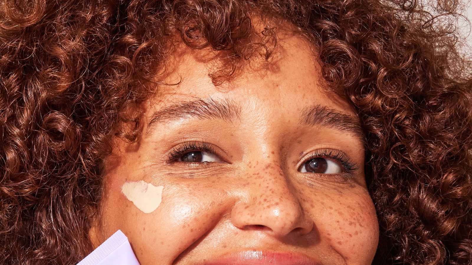 Face sunscreen that doesn't pill under makeup – smooth SPF application on the cheek