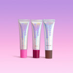 Three cosmetic Lip products from Naked Sundays standing upright on a soft pink to purple gradient background