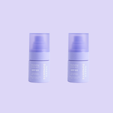 Two bottles of mini-sized Naked Sundays Hydrating Glow Mists SPF50 sitting against a purple background