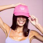 Woman wearing a pink cap with 'Sunday Mode' text on a pink background