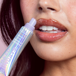 Person applying Naked Sundays PoutScreen Lip Treatment SPF50 with a colorful tube to their lips