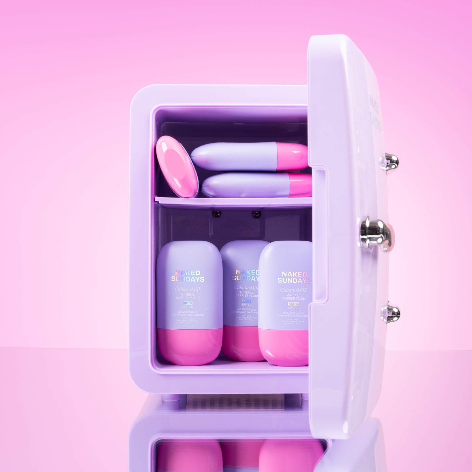 Lilac cosmetics fridge with pink and lilac CabanaMilk SPF50 products on a pink background