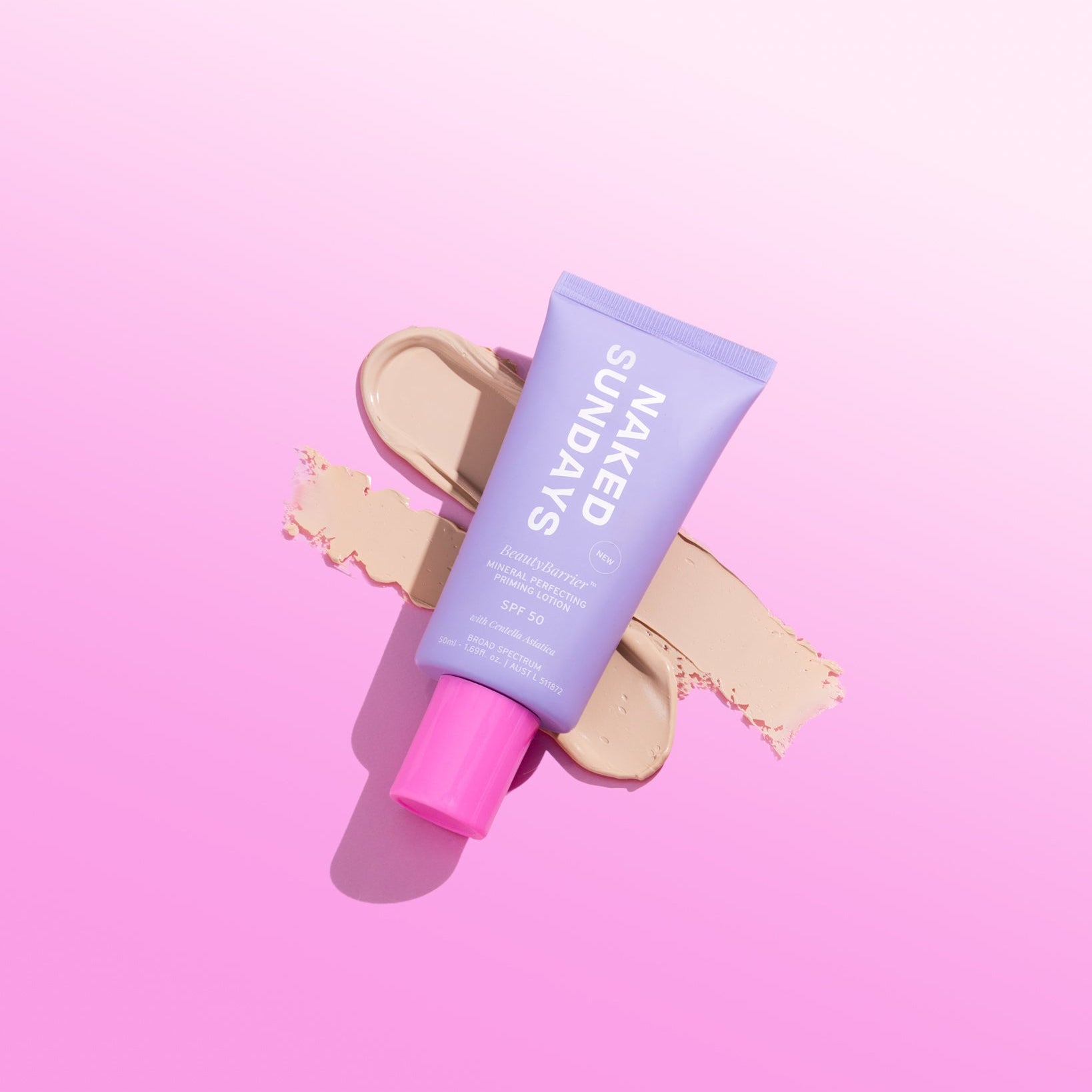 Naked Sundays purple sunscreen tube with pink cap on a pink background