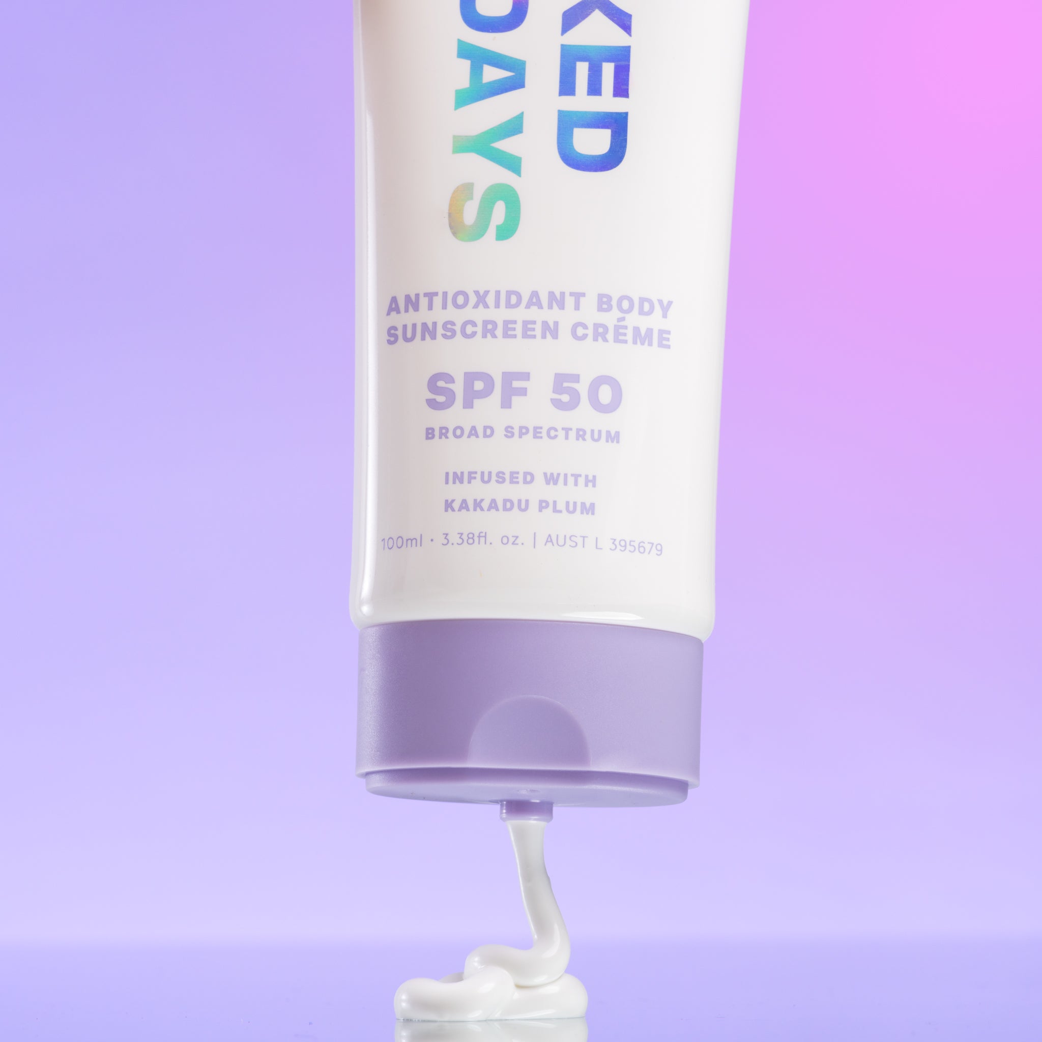Tube of Naked Sundays Antioxidant Body Creme being squeezed onto a purple surface.