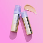 Two 'Naked Sundays' skincare products on a pink background with a swatch of beige color
