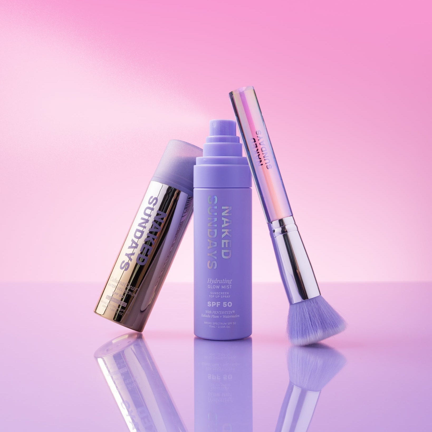 Naked Sundays SPF50 Glow Mist + CabanaClear Illuminating + SPF Brush Bundle on a pink + purple gradient background