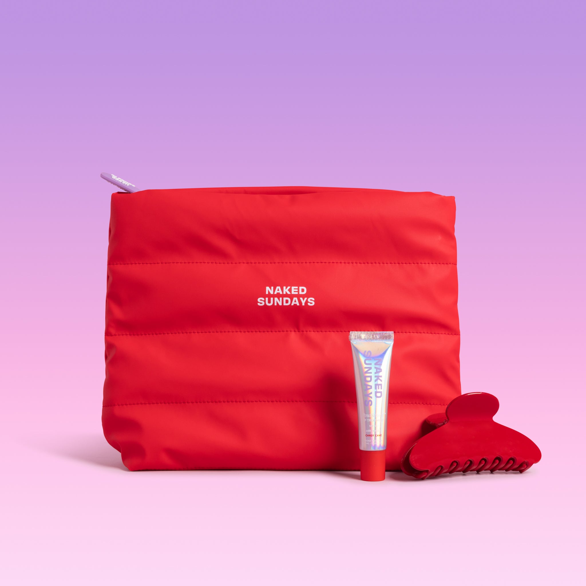 Red puffy cosmetic bag, Candy Cane SPF50 lip gloss tube, and a glossy red hair claw clip on a gradient background