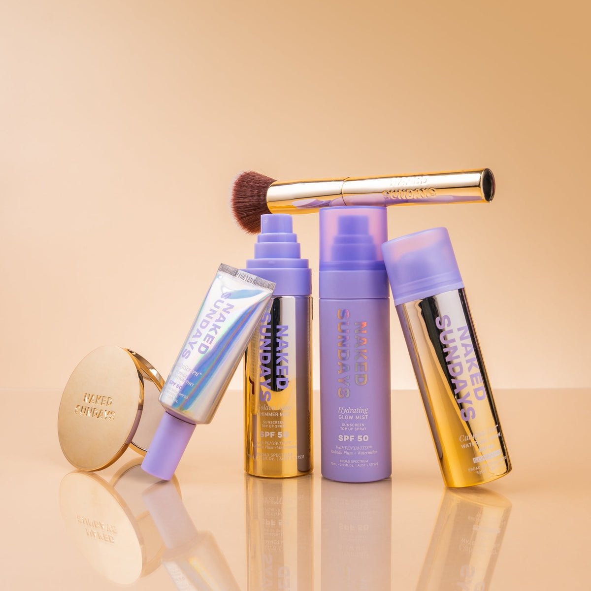 Naked Sundays SPF products stacked on a golden surface