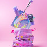 Collection of SPF products including a brush, Glow Mist mini, CabanaClear mini and drawstring bag on a pink background