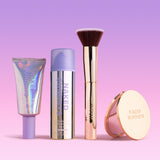 SPF Makeup products including BeautyScreen, CabanaClear in Illuminating, a gold compact mirror, and a gold brush with 'Naked Sundays' branding on a gradient pink and purple background