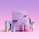 Collection of 'Naked Sundays' skincare products in front of a small refrigerator on a pink background