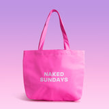 Pink tote bag with 'NAKED SUNDAYS' text on a pink background