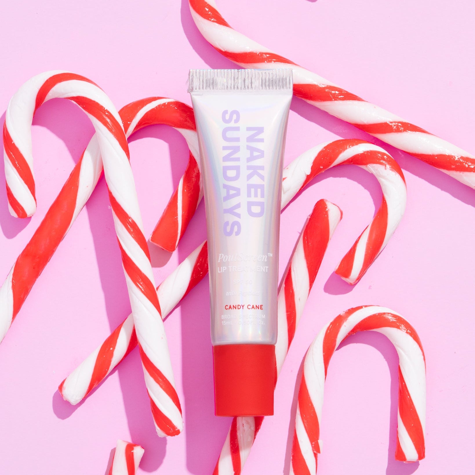 Naked Sundays limited edition Holiday Candy Cane Lip SPF on top of a pile of candy canes