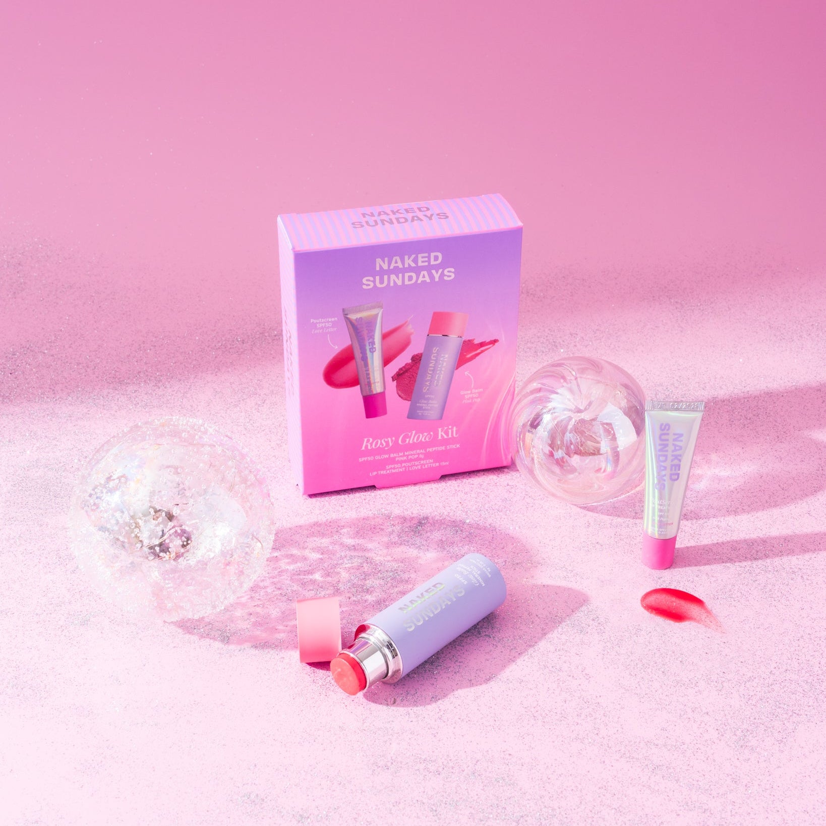 Naked Sundays lip and cheek products on a pink and glittery surface