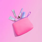 Pink makeup pouch with Naked Sundays SPF products on a pink background