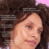 Woman with natural hair applying a skincare product, highlighting features on a pink background