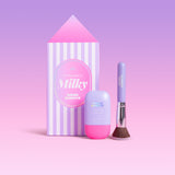 CabanaMilk SPF50 set with a striped house shaped box, mineral fluid bottle, and makeup brush in purple and pink tones