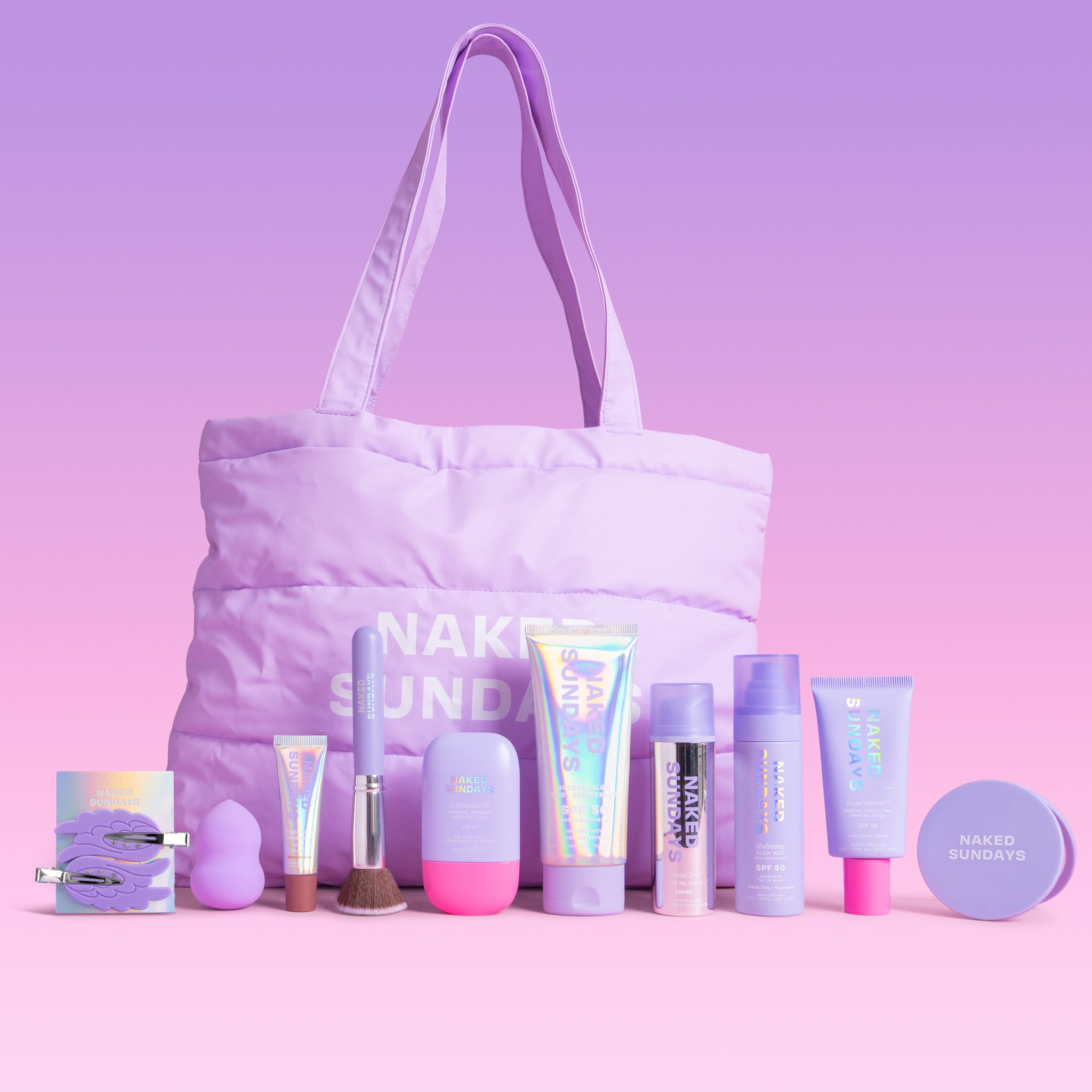 A pastel purple makeup bag with long handles sits on a pink lavender studio background, surrounded by matching cosmetic products from Naked Sundays